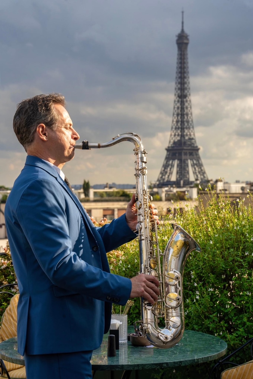 Saxophoniste jouant sur fond de lumières colorées de scène