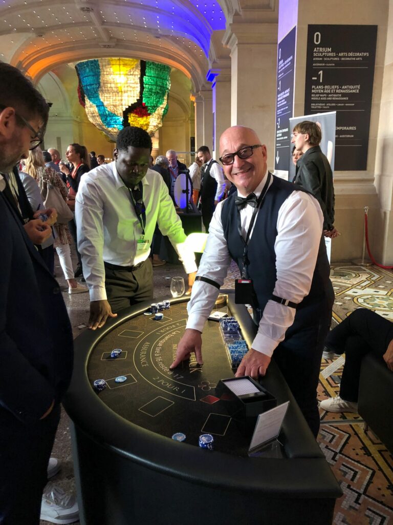 Croupier souriant avec nœud papillon devant table blackjack au Palais des Beaux-Arts de Lille Croupiers professionnels en tenue élégante